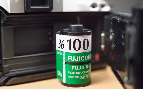 Vintage Fujicolor ISO 100 film cartridge with 36 exposures designed for color prints placed inside vintage camera body. Suitable for analog photography and DX-coded cameras.