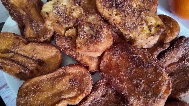 Close up view of traditional Spanish torrijas golden fried bread slices coated with cinnamon sugar served on white plate Easter festive homemade dessert food