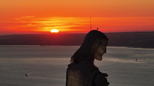 Silhouette of Christ the King in Lisbon at sunset with golden light and colorful sky.
4K high quality cinematic scenic footage.