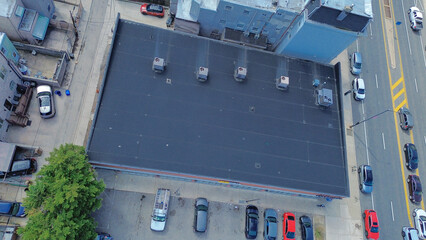 Commercial rooftop cluster near S 12th St and Snyder Ave features HVAC lined structures embedded in dense neighborhood blocks, crowded street. Dark roof membranes, metal units, Philadelphia, PA © trongnguyen