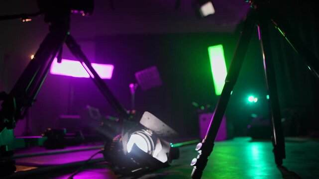 Background with camera slider with colorful lights, smoke, and backstage equipment. Concept of video production, filming technology, concert setup, media, and creative industry.