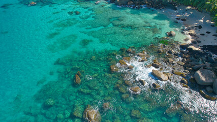 Fototapeta premium Aerial drone view of Tusculum Beach in Mahé, Seychelles, showcasing pristine striking granite boulders. Crystal-clear turquoise waters gently meet the shore