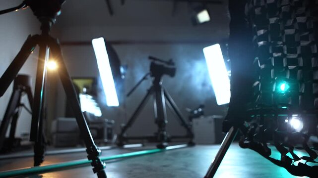 Blurred, defocused background camera slider with lights, smoke, and backstage equipment. Concept of video production, filming technology, concert setup, media, and creative industry.