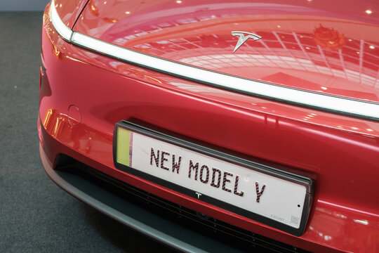 Tesla Model Y in red with sleek design displayed at exhibition