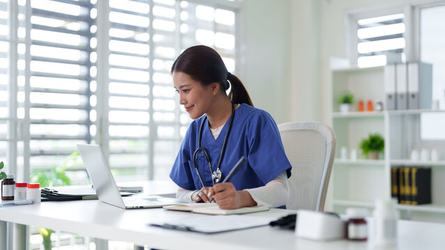 Asian adult female medical professional nurse doctor work laptop digital data healthcare records study online telemedicine consultation clinic office