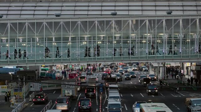 Twilight in Tokyo : Commuters Moving Along the Illuminated Skywalk at the Terminal Station Above Congested Roads with Glowing Car Lights | Shibuya Station, Tokyo, Japan