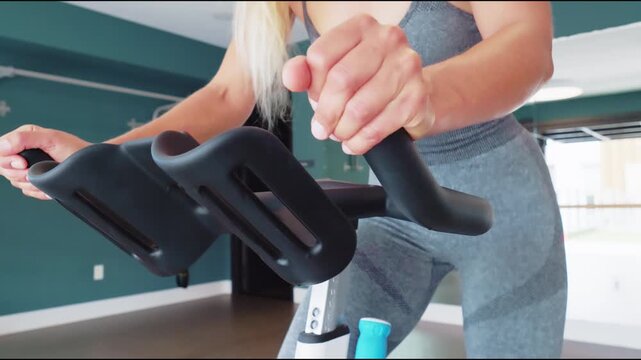 Woman Adjusting Exercise Bike in Home Workout Room