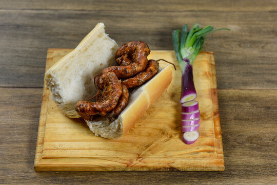 Cow bowels presented on a wooden board with ingredients, ready to grill