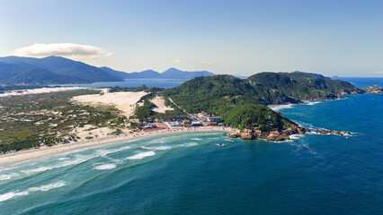 Lateral aerial view of Joaquina Beach with extensive white sand, dunes and urban area, Florianopolis. © Marcio Eneas