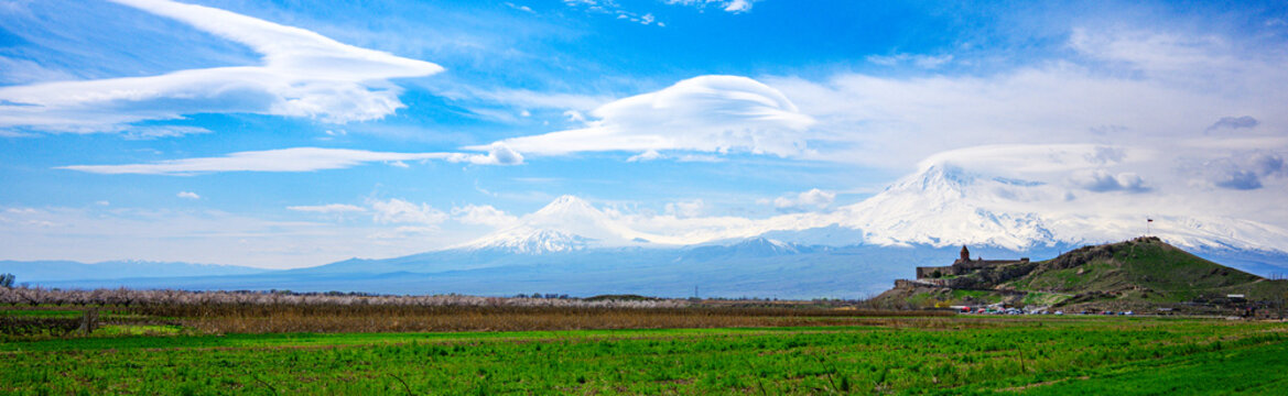 Khor Virap Monastery. Expansive grassy plain meets majestic snow-covered peaks under clear sky