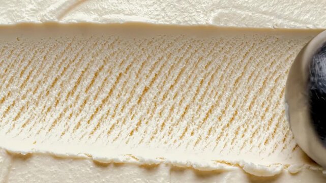 Ice cream scoop close up creamy vanilla texture with metal scoop carving smooth surface dessert frozen food macro background, ice cream footage.