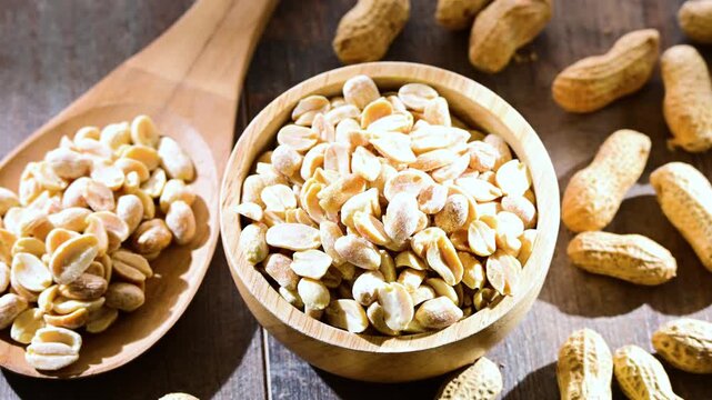 A bowl with peanuts on wooden table. Delicacies
