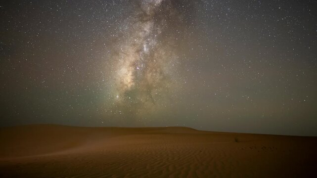 Wide angle time lapse of night Stars milky way moving across night sky in empty desert sand dune in the winter.