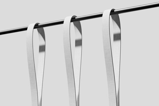 White lanyard straps hanging on a metal bar 