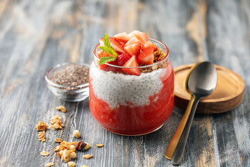 Chia seed pudding with granola, fresh berries and strawberry puree in a glass jar. Healthy breakfast © murziknata
