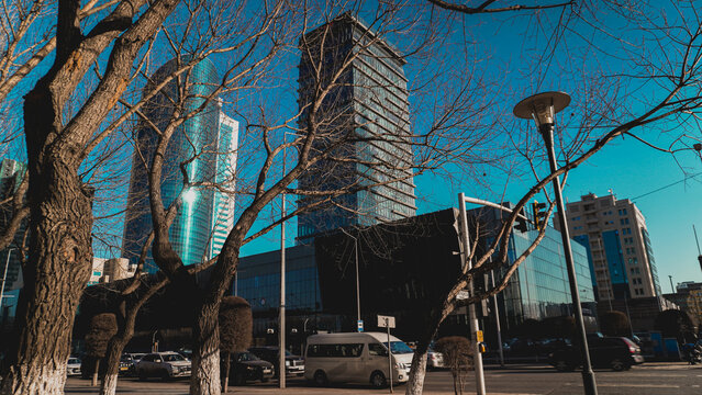 Astana, Kazakhstan - April 2026: View of Kaz media Center and modern skyscrapers through spring trees on the left bank of the city