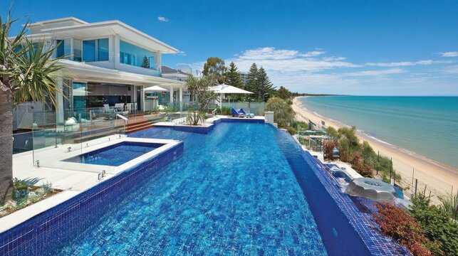 Luxury beachfront villa with infinity pool and ocean view on a sunny day
