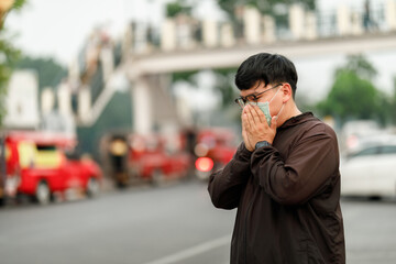 Fototapeta premium Man wearing N95 face mask for protection against hazardous PM2.5 air pollution and toxic smog in the city.