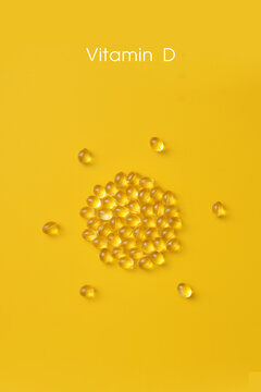 Vitamin D Capsules on Yellow Background, Minimal Supplement Concept