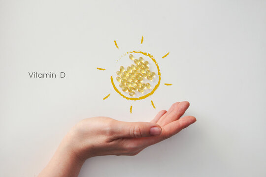 Hand Holding Vitamin D Capsule Sun, Immunity and Health Concept