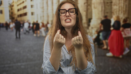 Fototapeta premium Young caucasian woman holds outstretched palms in pleading gesture on crowded street; survival desperation.