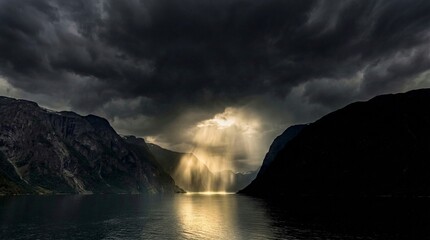 Dramatic Sun Rays Breaking Through Storm Clouds Over Mountain Lake © Narasimha