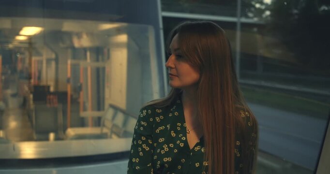 beautiful young slender woman with pleasant appearance in long dress in subway train while moving. natural Ukrainian European female beauty. German public transport Metro train tram. woman face close 
