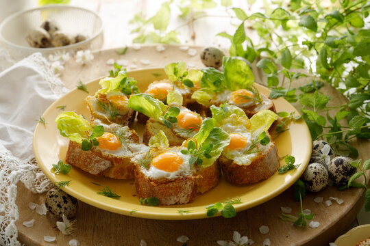 Sandwiches with fried quail eggs, lettuce and herbs. A delicious Easter breakfast.