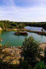 Obraz premium Old basalt quarry transformed into a lake, combining industrial geology and untouched nature scenery.