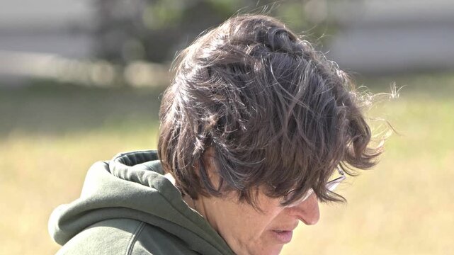 Slow Motion clip of older woman walking away in disgust outside sunny day