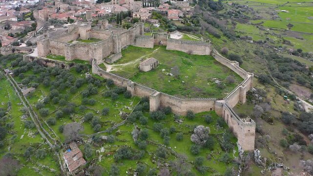 Aerial view of Trujillo Castle ruins in Caceres, Spain. Historic hilltop fortress remains open to visitors, medieval stone structures overlooking Castilla La Mancha landscape.