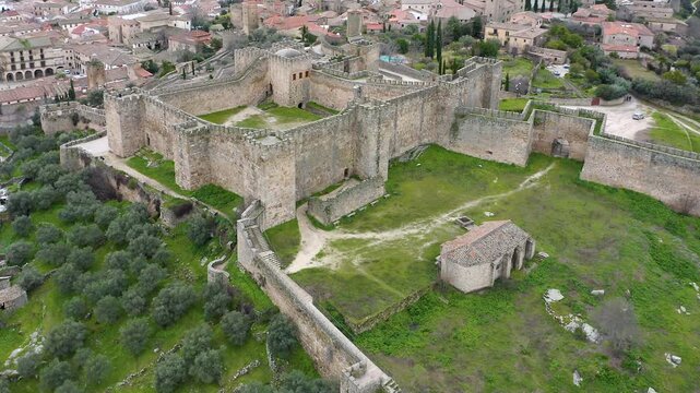 Aerial view of Trujillo Castle ruins in Caceres, Spain. Historic hilltop fortress remains open to visitors, medieval stone structures overlooking Castilla La Mancha landscape.
