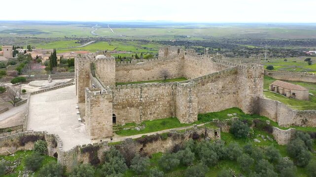 Aerial view of Trujillo Castle ruins in Caceres, Spain. Historic hilltop fortress remains open to visitors, medieval stone structures overlooking Castilla La Mancha landscape.