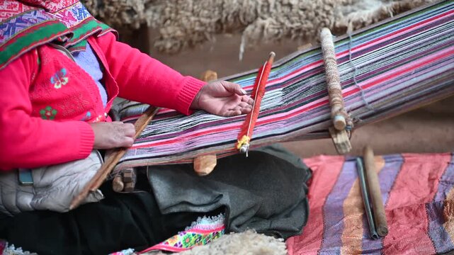 Peruvian woman weaving colorful traditional textiles