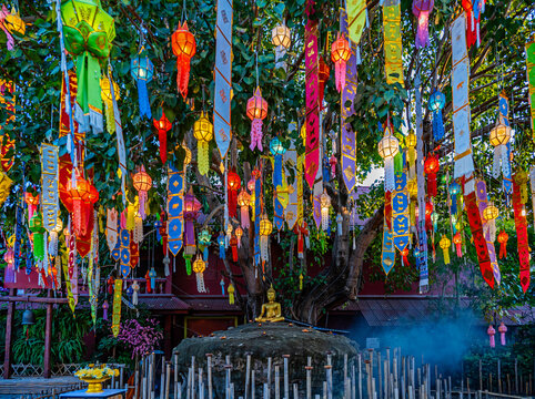 Chiang Mai, Thailand - Golden Buddha statue at Wat Pantao Temple with colorful lanterns hanging on a Bodhi tree