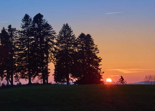 Woman with a mountain bike enjoying a scenic sunset in the Allg&auml;u region, Germany. Outdoor adventure, freedom, and active lifestyle in a peaceful alpine landscape with warm evening light.
