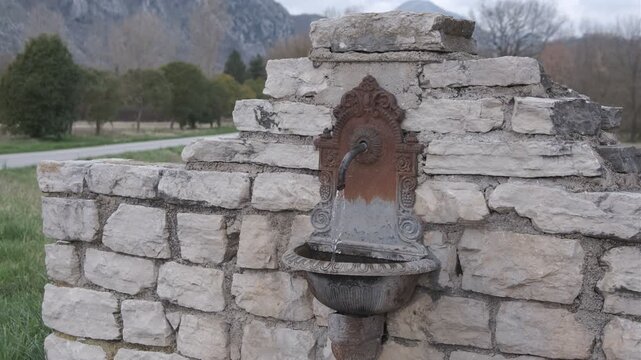 Antique cast iron wall fountain on rustic stone wall in the Italian countryside, Rocchetta a Volturno, Molise.
