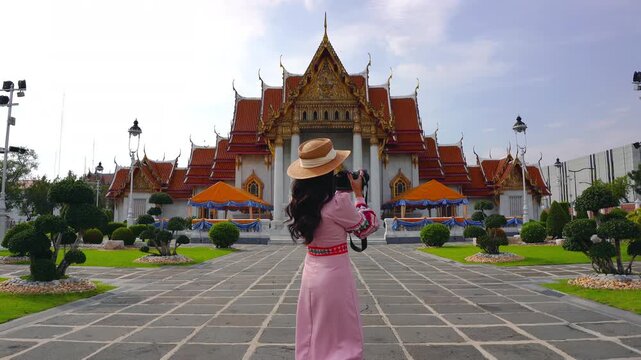 Tourists visiting at Wat Benchamabophit or the Marble Temple in Bangkok, Thailand.