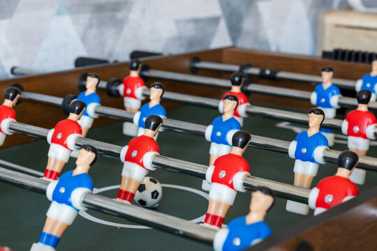 Foosball table with players and ball in indoor game setup
