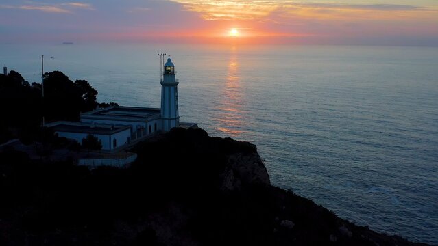 Aerial viewof a beautiful sunrise over the sea horizon, in the lighthouse of La Nao Cape, Alicante, Spain. 
