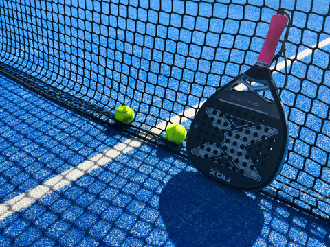 Faro, Portugal, February 18, 2026 Top view of a padel racket nox and a tennis ball placed on a blue court with white lines, symbolizing the sport and its equipment.