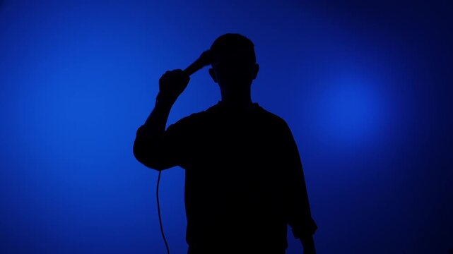Stylized silhouette of a male singer passionately performing into a microphone on a vibrant blue background, capturing live show energy, emotion and dramatic stage presence