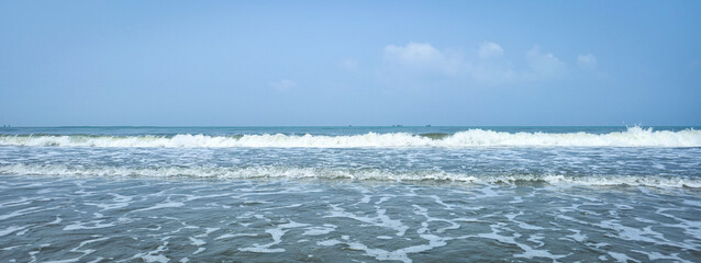 A high-quality collection of ocean waves crashing on the shore with white sea foam and splashing water against a clear blue sky, perfect for coastal tourism, summer vacation, and natural background. © Shuvro