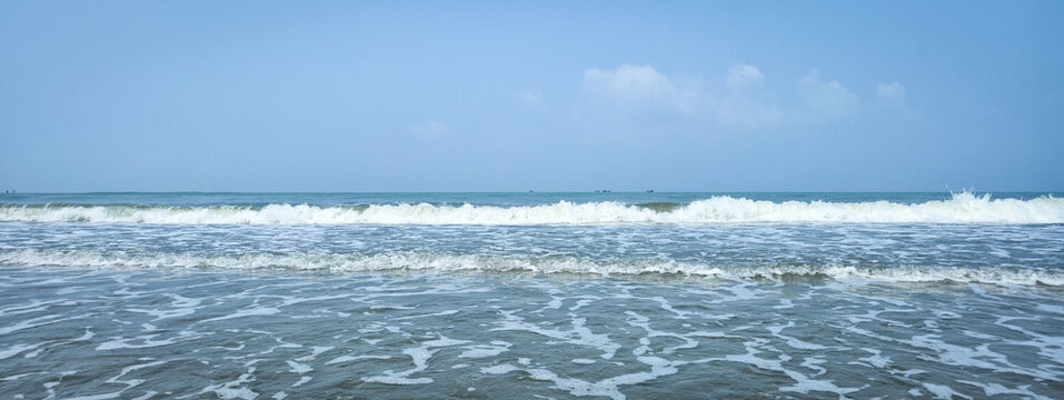 A high-quality collection of ocean waves crashing on the shore with white sea foam and splashing water against a clear blue sky, perfect for coastal tourism, summer vacation, and natural background.