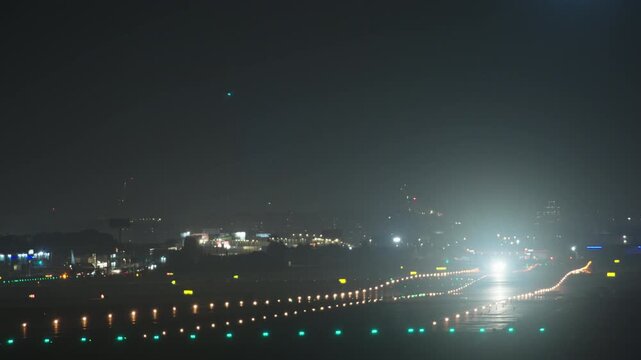 Passenger aircraft accelerating for takeoff on the illuminated runway of Valencia airport at night