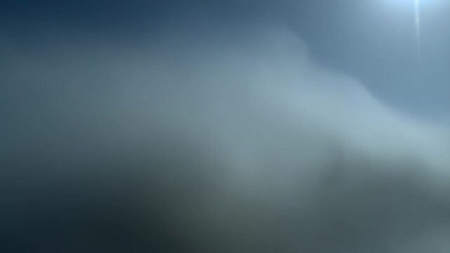 View of thick white and gray clouds smoothly changing shape and moving in sky, creating atmospheric landscape.
