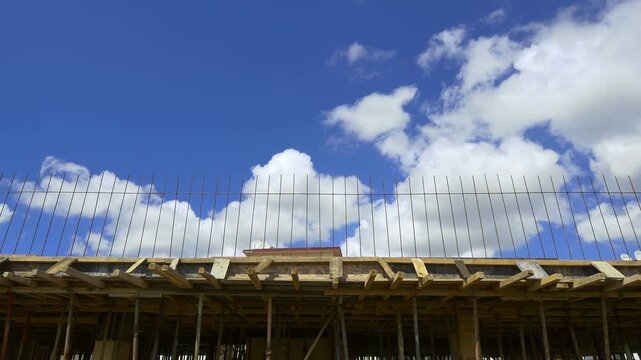 New-build constructions the most irresistible form of image pollution. Ubiquitous construction materials bisect sky and clouds scene. 4K, Timelapse
