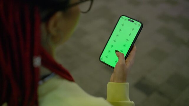 Woman with red dreadlocks using smartphone green screen