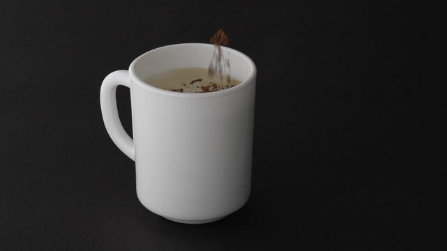 Mockup_instant_coffee_granules_falling_into_white_cup_black_background_4K