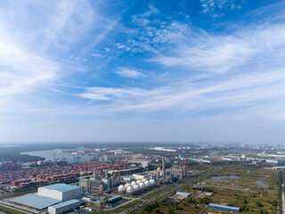 Obraz premium City skyline with a large industrial area in the background. The sky is clear and blue with a few clouds